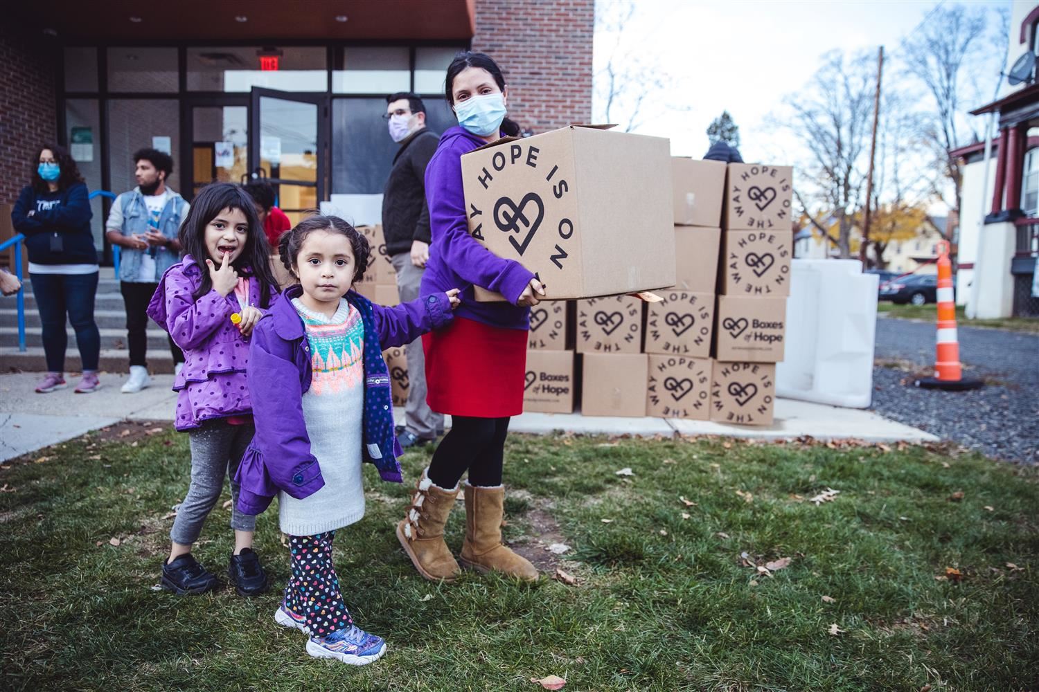 Family carries a box of food donated by CAF